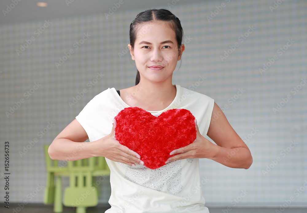 Portrait of young asian girl holding red heart shape pillow. Portrait of young asian girl holding red heart shape pillow.