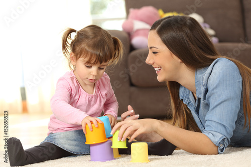 Mother and baby daughter playing at home