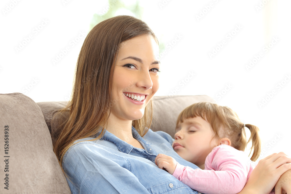 Mother looking at you with her daughter sleeping Mother looking at you with her daughter sleeping