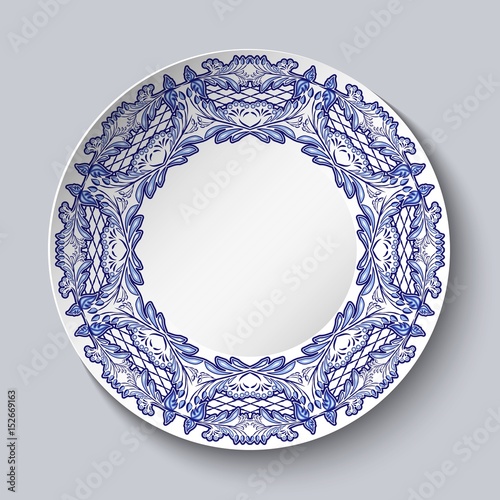 Plate decorated with blue floral patterns in the style of the national porcelain painting with empty space in the center isolated on gray background.