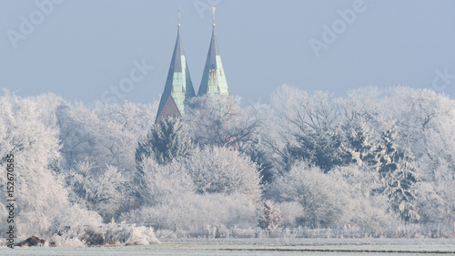 Dorf mit Dorfkirche im Winterschlaf bei frostigen Temperaturen