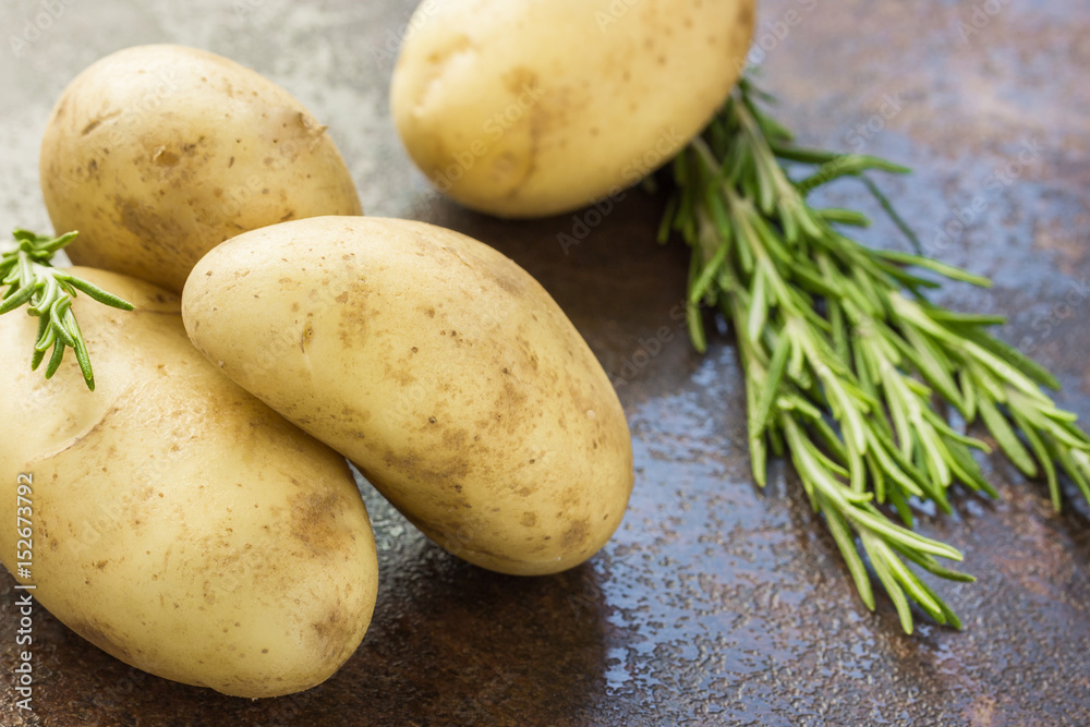 Raw potatoes and fresh herbs on a murble background. Raw potatoes and fresh herbs on a murble background.