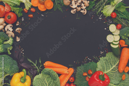 Frame of fresh vegetables on black background with copy space