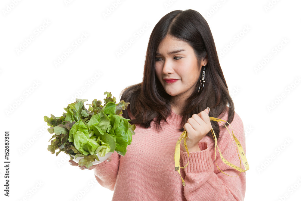 Unhappy Asian woman with measuring tape and salad. Unhappy Asian woman with measuring tape and salad.