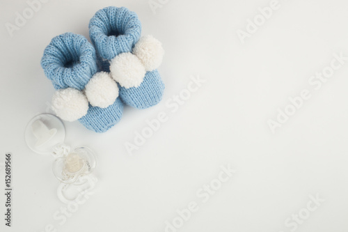 Cute little baby shoes or booties on white background, top view, copy space, Concept of Infancy and motherhood. 