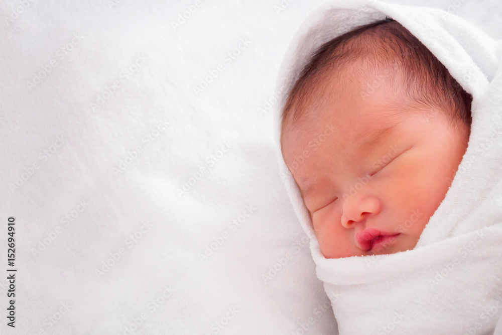 Cute newborn asian baby girl sleeping on white fabric Cute newborn asian baby girl sleeping on white fabric
