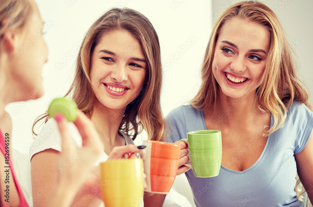 happy young women drinking tea with sweets at home happy young women drinking tea with sweets at home