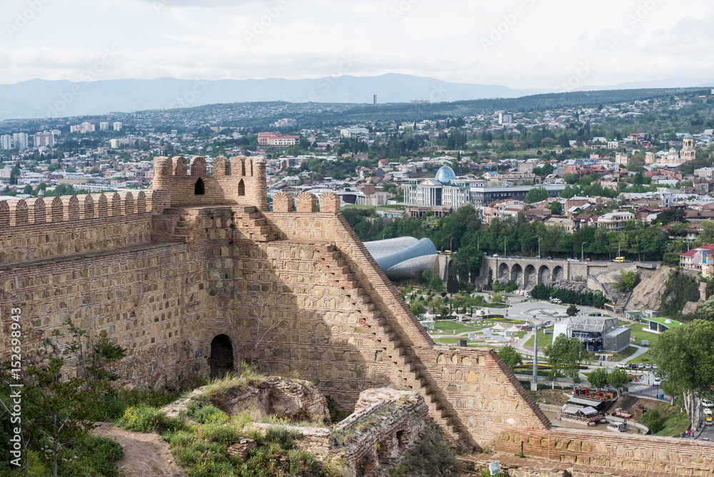 Wall of ancient Narikala castle and city of Tbilisi on the background