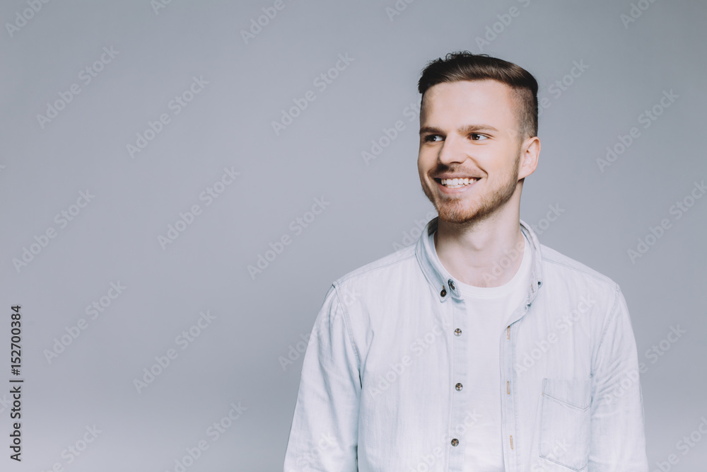 Standing smiling young man with beard in a white shirt Standing smiling young man with beard in a white shirt