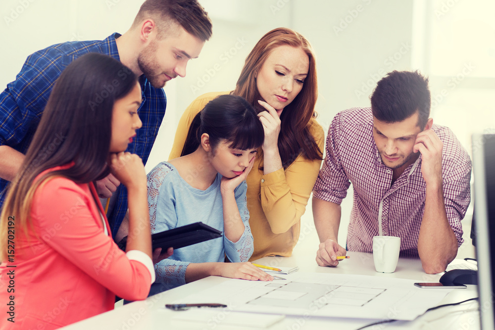 creative team with blueprint working at office creative team with blueprint working at office