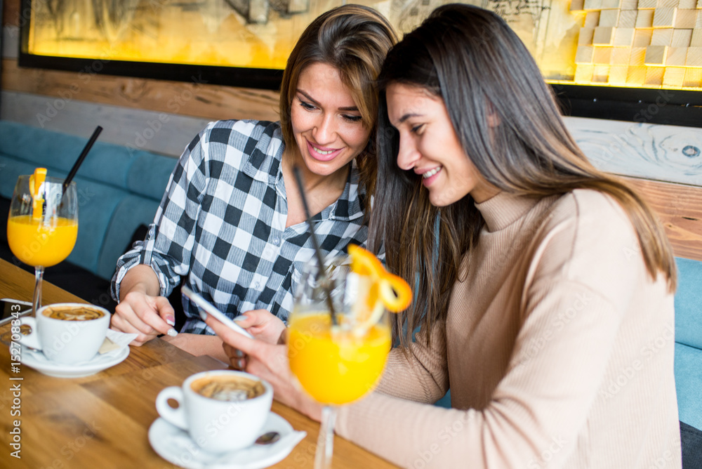 Two young female friends sitting in cafe Two young female friends sitting in cafe