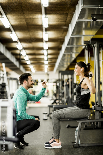 Woman exercise in a gym with the help of her personal trainer