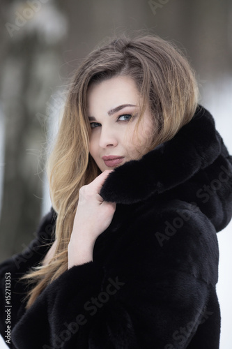 Fashionable winter portrait of lady with long hair in city