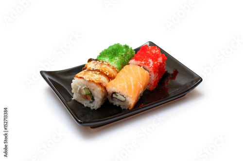 rolls assorted with flying fish caviar, eel, salmon on black plate on white background