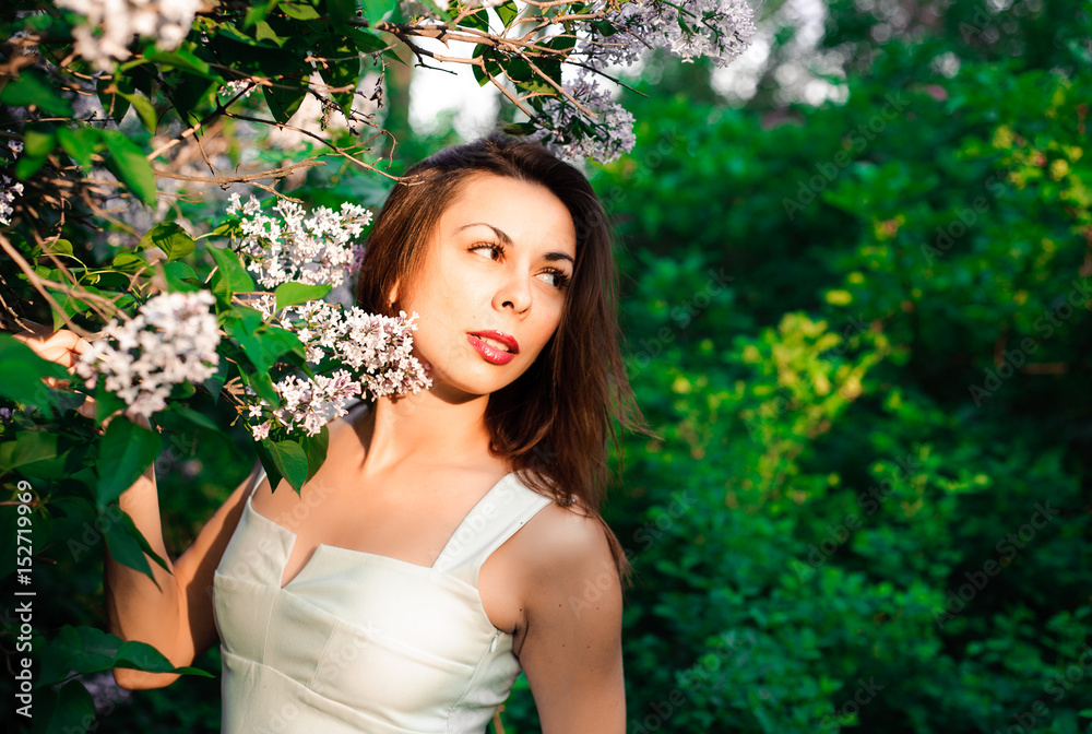  Young girl in complete tranquility and pacification in a beautiful and elegant dress on nature in the spring in the park