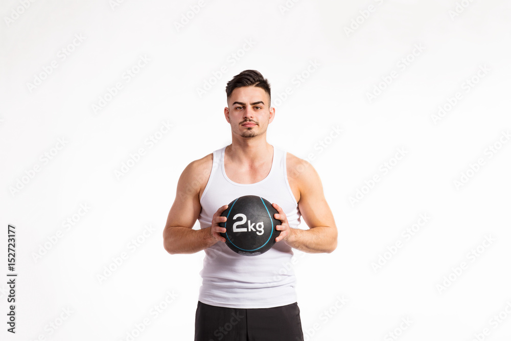 Handsome fitness man holding medicine ball, studio shot. Handsome fitness man holding medicine ball, studio shot.