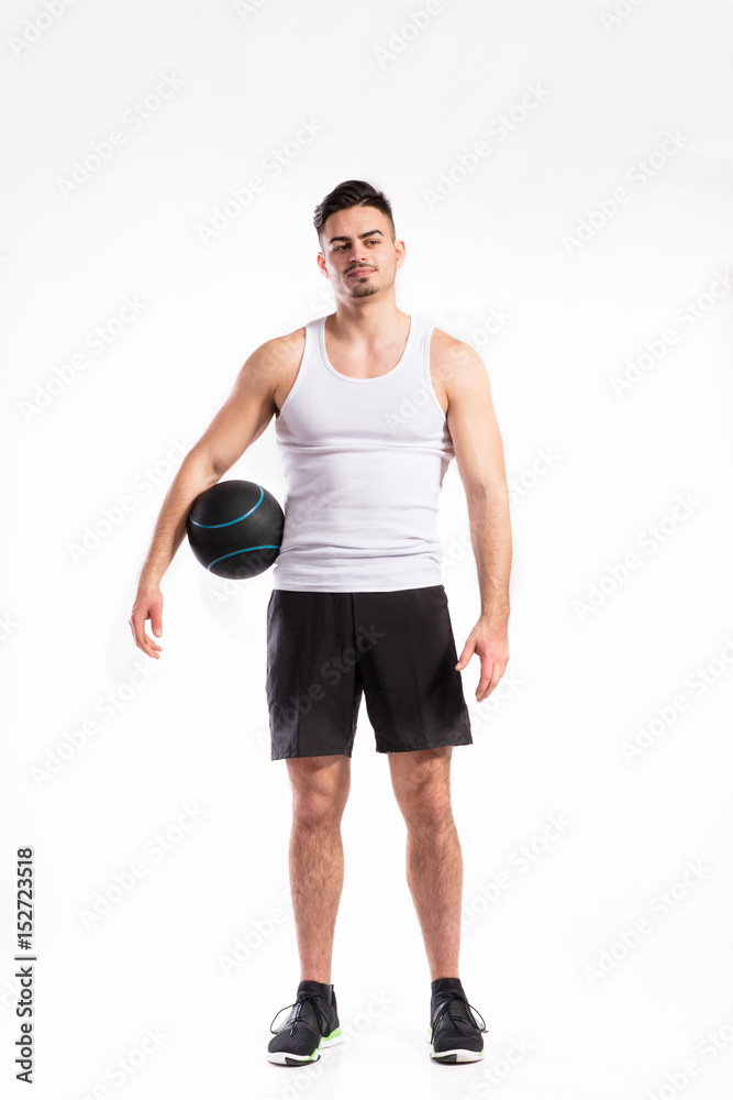 Obraz premium Handsome fitness man holding medicine ball, studio shot.