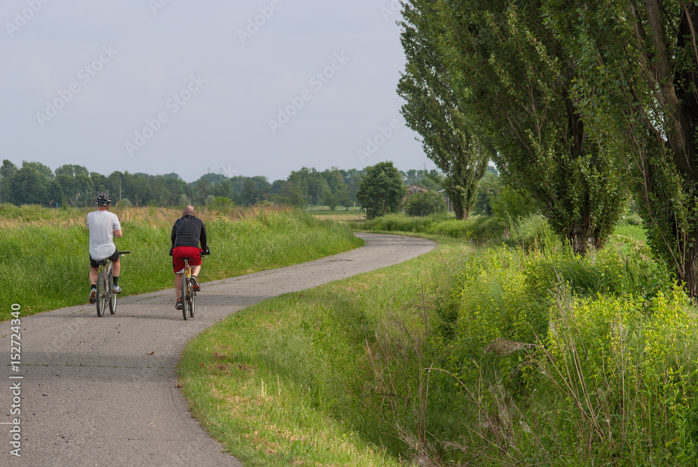 Obraz premium ciclisti su strada di campagna