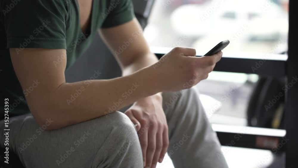 Muscular arms of strong male athlete scrolling website online on smartphone Muscular arms of strong male athlete scrolling website online on smartphone