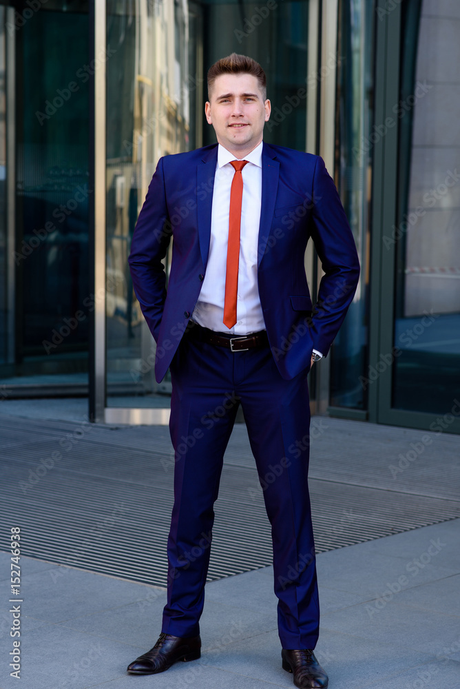 Man in a blue suit and red tie buttoning his suit jacket Stock Photo |  Adobe Stock