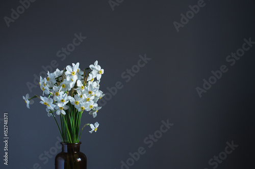 White daffodils in a brown glass jar