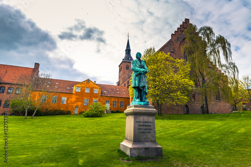 Odense, Denmark - April 29, 2017: Cathedral of Saint Canute and Statue of Hans C Andersen