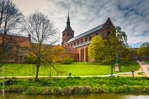 Fotografie Odense, Denmark - April 29, 2017: Cathedral of Saint Canute and Statue of Hans C