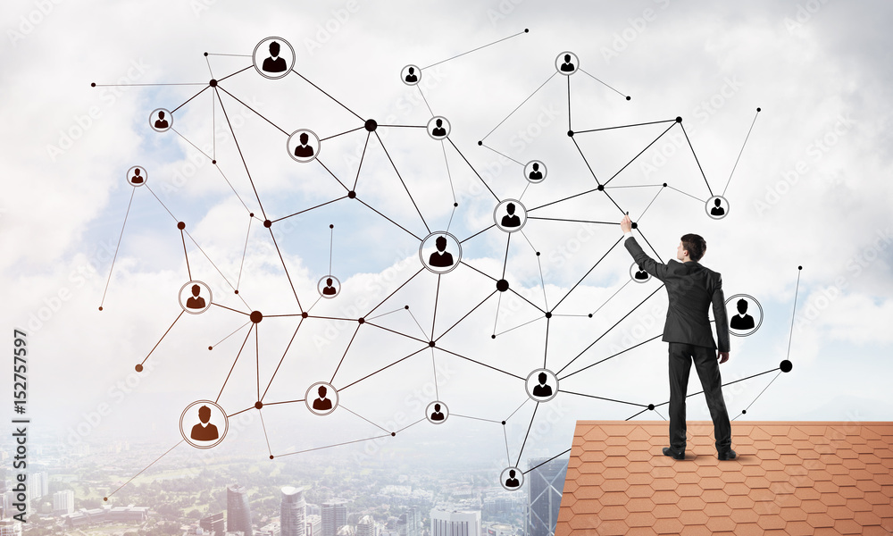 Businessman on house roof presenting networking and connection concept. Mixed media Businessman on house roof presenting networking and connection concept. Mixed media