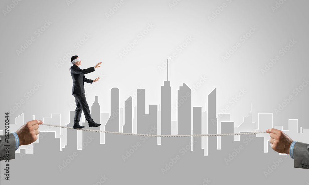 Business concept of risk support and assistance with man balancing on rope Business concept of risk support and assistance with man balancing on rope