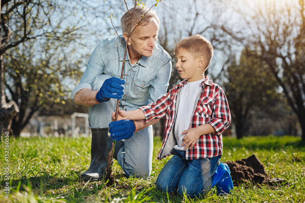 Fototapeta premium Senior man teaching child how to take care of nature