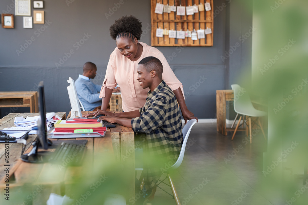 Fototapeta premium Smiling African business colleagues at work in a modern office
