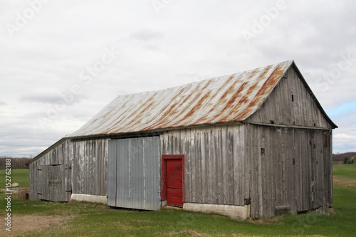 Old abandoned wood barn with red door