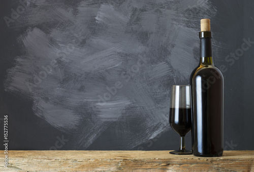 Red wine bottle on a wooden background photo