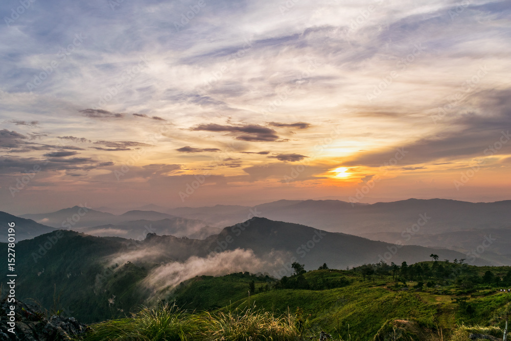 Beautiful landscape nature on mountain with sun cloud fog and bright colors of sky and sunlight during sunset in winter at view point Phu Chi Fa Forest Park in Chiang Rai Province, Thailand