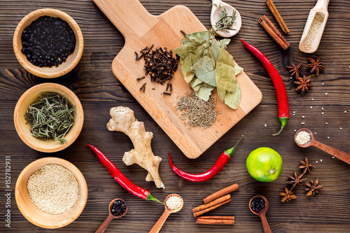 Spices, chili and herbs on wooden kitchen table background top view
