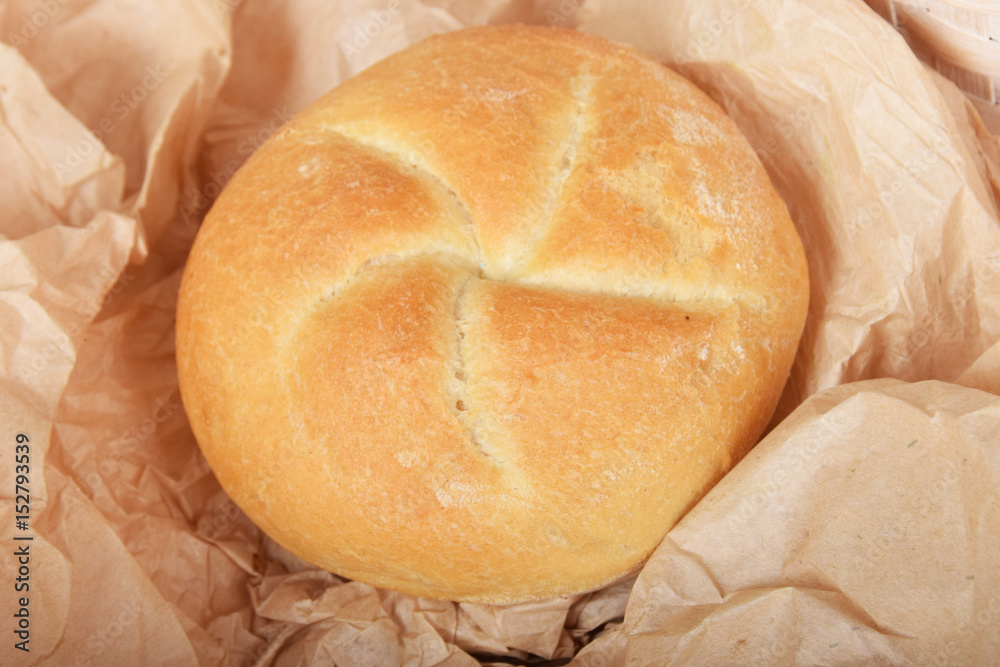 Fresh baked roll wrapped in parchment paper Fresh baked roll wrapped in parchment paper