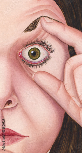 Woman holdingher left eye open. photo