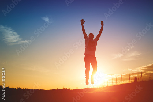Silhouette of man jumping on sunset background