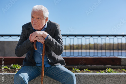 Brooding pensioner peering into the distance in the park