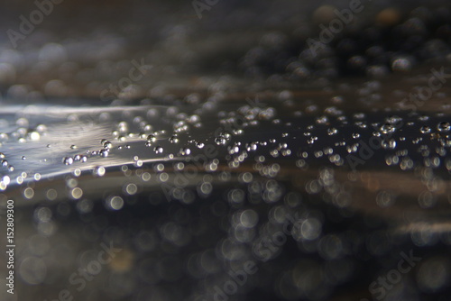 water drops on foil, black and brown background, focus, blurry