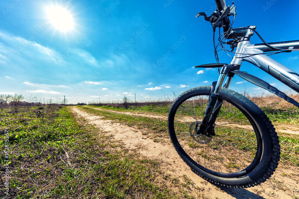 Obraz premium Mountain biking down hill descending fast on bicycle. View from bikers eyes.