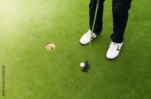 Golfer preparing for a putt on the green.