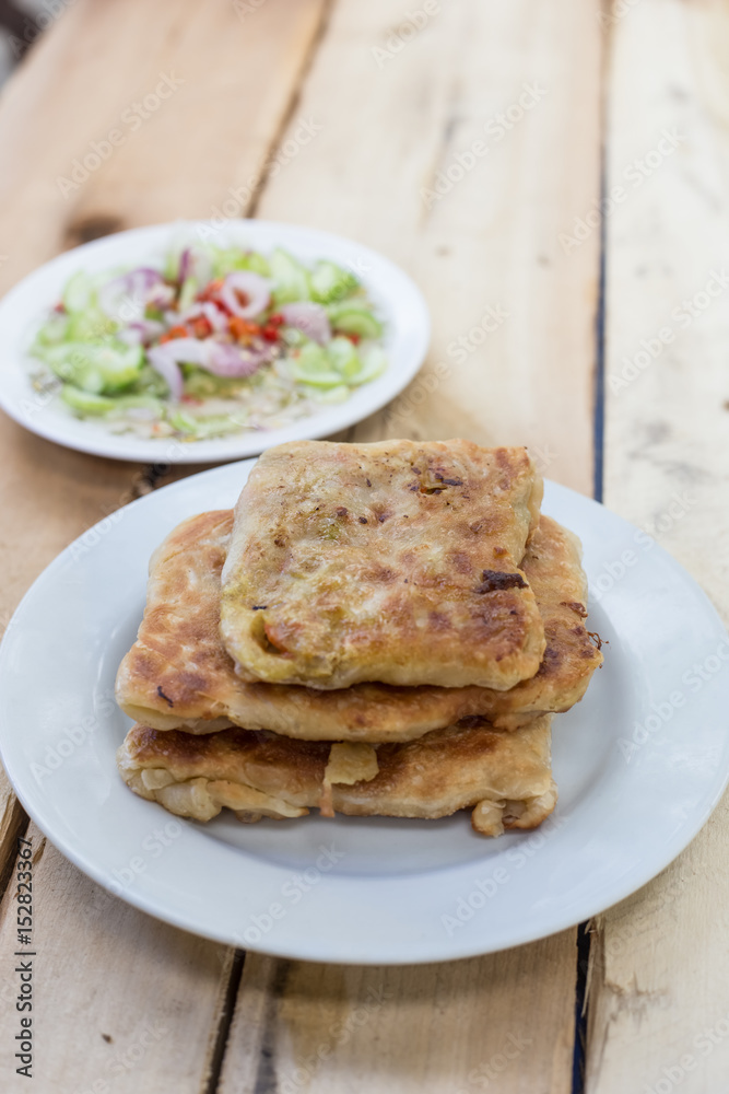 Roti Parata or Roti canai with curry sauce on wooden background. Roti Parata or Roti canai with curry sauce on wooden background.