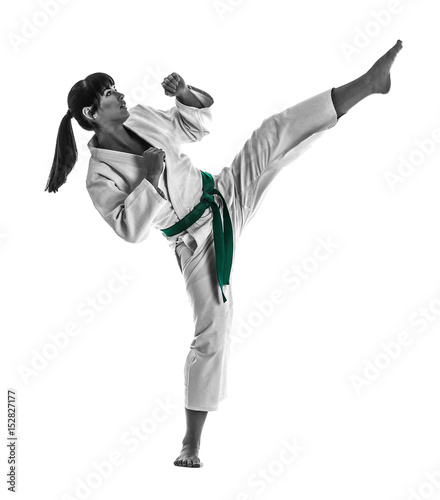 Young sporty woman practicing martial arts on white background