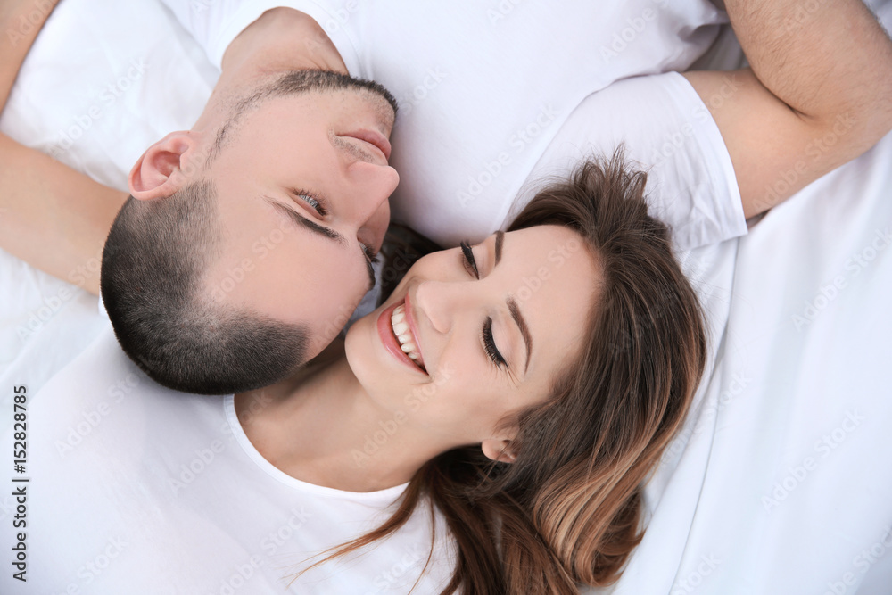 Young couple lying together in bed Young couple lying together in bed