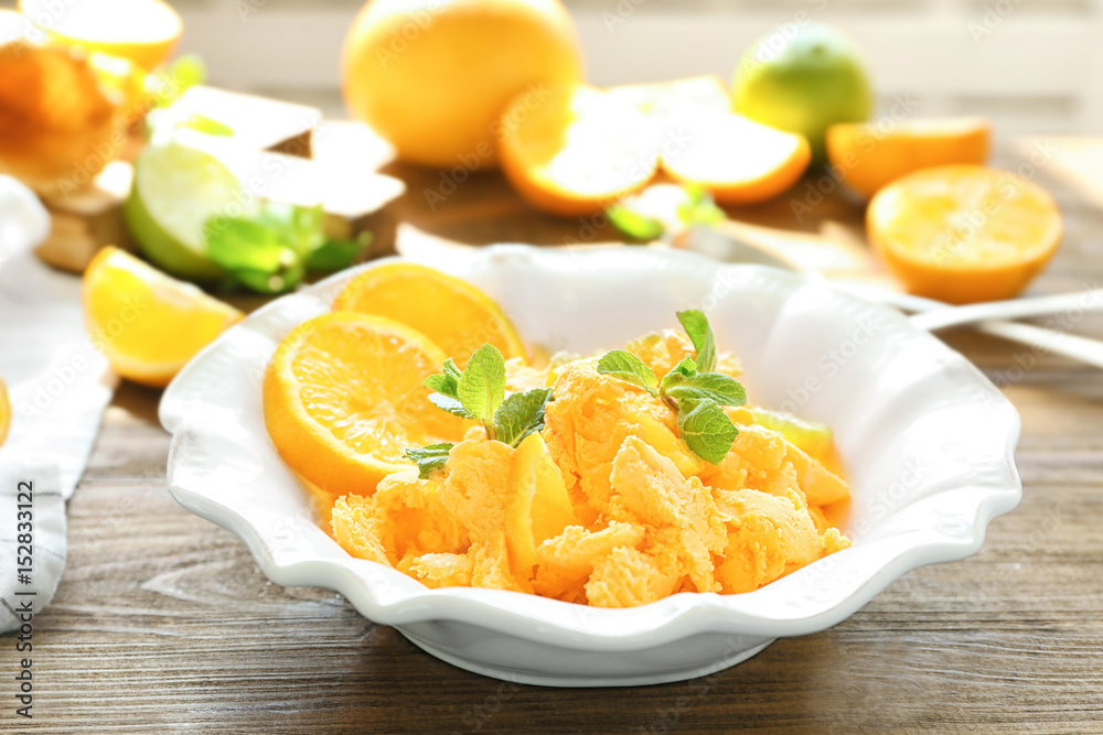 Plate with delicious citrus ice cream on wooden table Plate with delicious citrus ice cream on wooden table