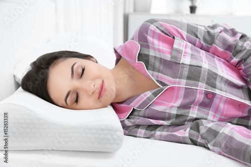 Young woman lying on bed wi...