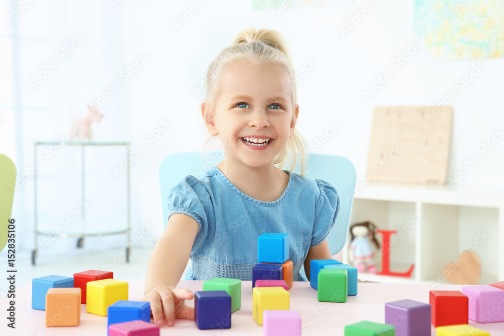 Cute little girl playing with colorful cubes at home Cute little girl playing with colorful cubes at home