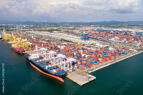 Aerial view of cargo ships loading containers at seaport.