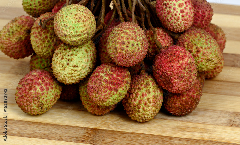 Bunch of lychee on old wooden cutting board Bunch of lychee on old wooden cutting board